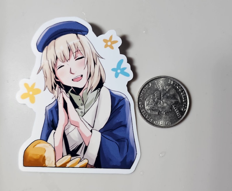 May include: A sticker featuring a cartoon illustration of a young woman with blonde hair wearing a blue beret and a blue and white jacket. She is smiling and holding her hands together in front of her. The sticker has a white background with yellow and blue flowers.