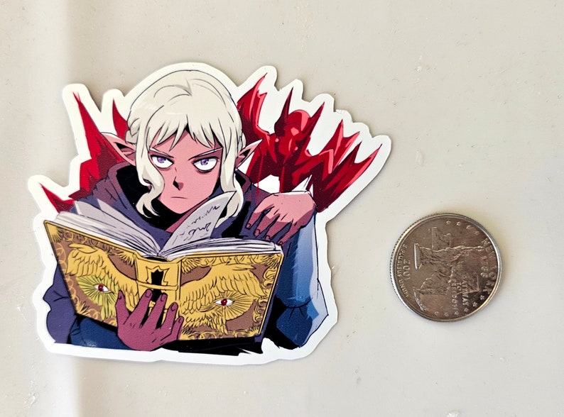 May include: A sticker featuring a white-haired elf character with purple eyes, wearing a blue robe and holding a golden book with red eyes on the cover. A red demon with wings is behind the elf.