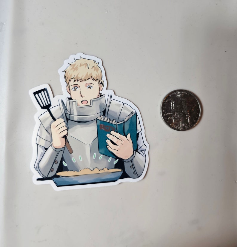 May include: A sticker featuring a cartoon man in armour, holding a spatula and a cookbook, standing in front of a pan of food. The man has blonde hair and a surprised expression. The cookbook has the word "Recipes" on the cover.