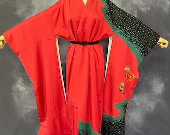 May include: A red kimono with a black and green patterned design. The kimono has a black belt and floral embroidery.
