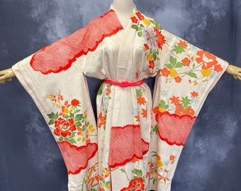 May include: A white kimono with a red and white floral pattern. The kimono has a red sash and is displayed on a mannequin.