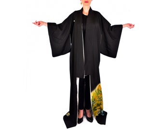 May include: A black kimono with long sleeves and a white lining. The kimono has a colourful floral pattern on the bottom hem.