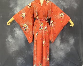 May include: A traditional Japanese kimono with a floral pattern in shades of red, white, and yellow. The kimono is made of silk and has a long, flowing silhouette.
