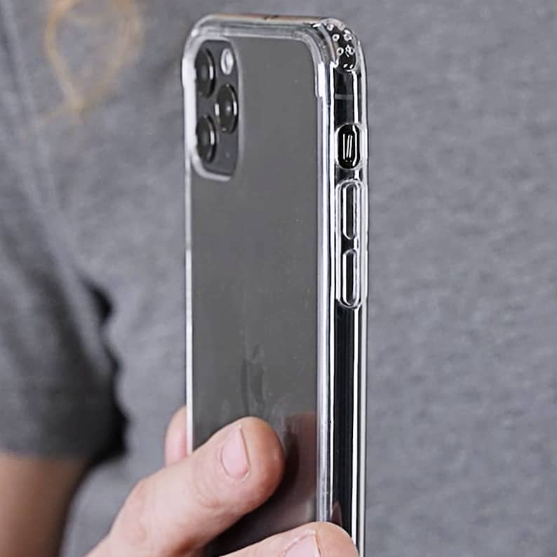 May include: A clear phone case with a black phone inside. The case has a raised lip around the camera lens and buttons.