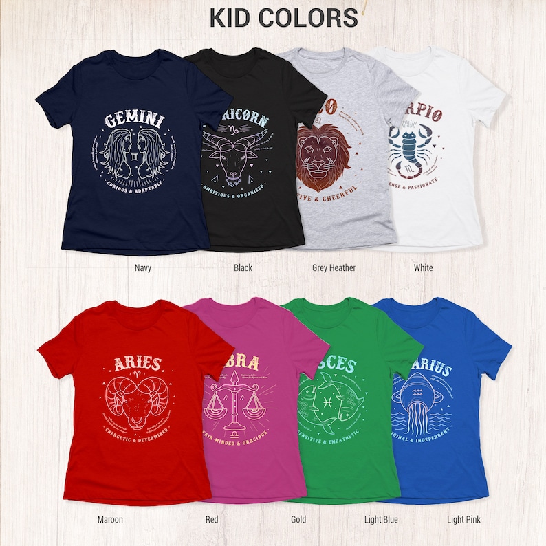 May include: A set of 10 t-shirts featuring zodiac signs with their corresponding traits. The shirts are available in a variety of colors, including navy, black, grey heather, white, maroon, red, gold, light blue, and light pink.