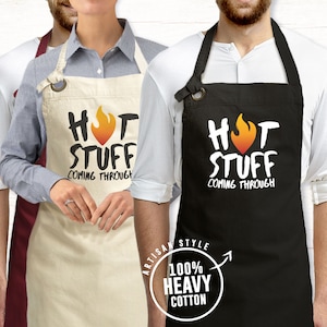 May include: Two black and white aprons with the text "Hot Stuff Coming Through" and a flame graphic. The aprons are made of 100% heavy cotton.