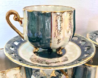 May include: A set of vintage teacups and saucers. The teacups are teal and white with gold trim and a gold handle. The saucers are white with a teal border and gold trim. The teacups have small gold feet and a grape vine design.