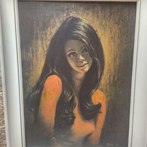 Könnte beinhalten: Ein gerahmter Vintage-Druck einer Frau mit langen dunklen Haaren. Die Frau trägt ein helles orangefarbenes Oberteil und blickt direkt auf den Betrachter. Der Hintergrund ist dunkelbraun und goldfarben. Der Druck ist mit "S.Penne 67" signiert.