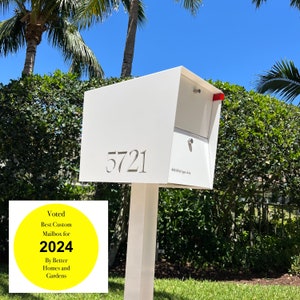 Puede incluir: Buzón moderno blanco con una pegatina amarilla que dice "Voted Best Custom Mailbox for 2024 By Better Homes and Gardens". El buzón tiene el número de casa 5721 y la dirección 456 Michigan Ave.