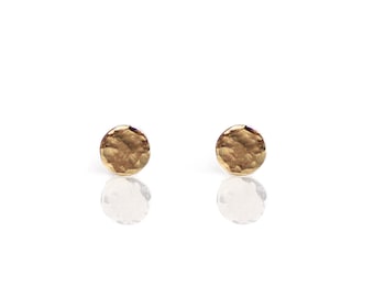 May include: A pair of gold hammered circle stud earrings.
