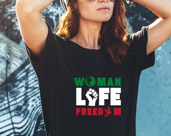 May include: A black t-shirt with white text that reads "WOMAN LIFE FREEDOM" with a green peace symbol, a black fist, and a green marijuana leaf.