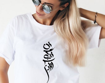 May include: A white t-shirt with a black Arabic calligraphy design. The design is a vertical line of text that reads "You are my strength".