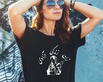 Peut inclure: Un t-shirt noir avec un motif blanc représentant une femme portant un foulard et le texte "You can't break a woman who rises" en farsi.
