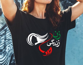 May include: A black t-shirt with a white graphic design featuring a woman's silhouette with flowing hair, a red heart, and the text "زن زندگی آزادی" in green and white.