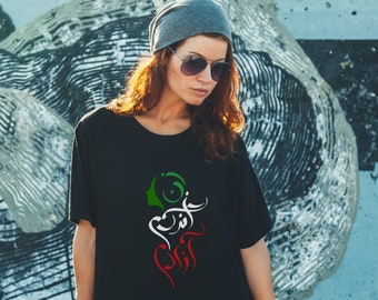 May include: A black t-shirt with a white and green graphic design featuring a woman's face and Arabic calligraphy. The design is in the colors of the Iranian flag.