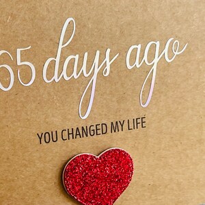 May include: A brown card with the text "365 days ago you changed my life" and a red glitter heart.