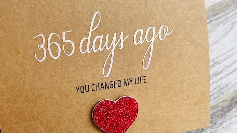 May include: A brown card with the text "365 days ago you changed my life" and a red glitter heart.