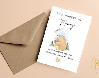 May include: A white card with a brown bear and a smaller bear cub. The card reads "To a wonderful Mommy. On your first Mother's Day you're an amazing Mom to Emma."