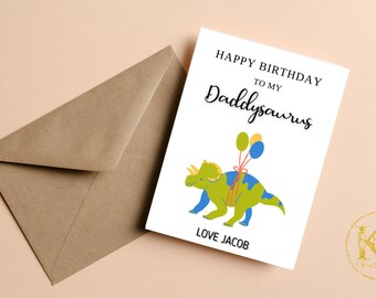 May include: A white card with the text "Happy Birthday to my Daddysaurus" in black. A green dinosaur with blue and yellow balloons is illustrated on the card. The text "Love Jacob" is at the bottom of the card.
