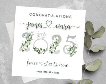 May include: A white card with green floral accents and the text "Congratulations James & Ciara 2025 forever starts now 10th January 2025".