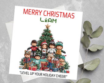 May include: A Christmas card with the text "MERRY CHRISTMAS LIAM" in red and green. The card features a group of cartoon figures in winter attire standing around a Christmas tree and presents. The phrase "LEVEL UP YOUR HOLIDAY CHEER!" is at the bottom.