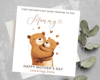 May include: A white card with a brown bear and a smaller brown bear hugging. The text on the card reads "First Mother's Day Hugs From Me To You Mummy" and "Happy Mother's Day Love & Hugs, Emma".