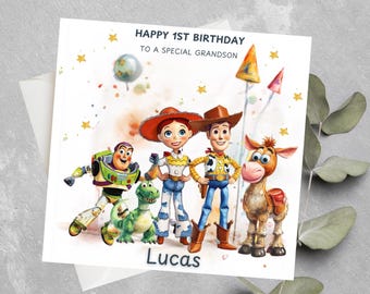 May include: A birthday card featuring the Toy Story characters Woody, Buzz Lightyear, Jessie, Rex, and Bullseye. The card has a watercolor background with gold stars and the text "Happy 1st Birthday to a special Grandson" and "Lucas".