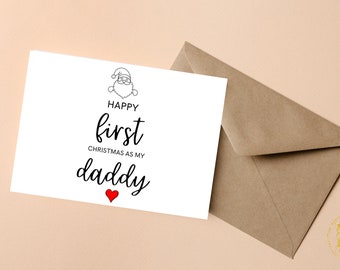 May include: A white card with a black and white illustration of Santa Claus. The card says "Happy first Christmas as my daddy" with a red heart.
