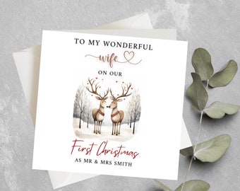 May include: A Christmas card with a couple of reindeer kissing in a snowy forest. The card says "To my wonderful wife on our first Christmas as Mr. & Mrs. Smith."