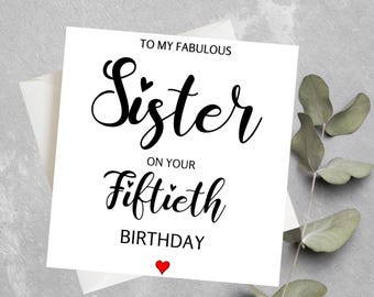 May include: A white card with black text that reads "To my fabulous Sister on your Fiftieth Birthday". A small red heart is at the bottom of the card.