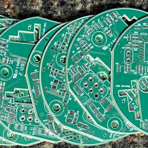 May include: A stack of six green circuit boards with copper traces and various components. The top board has the text "B21 2" and "2/6" printed on it.