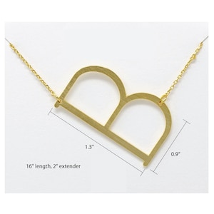 May include: Gold-tone necklace with a large, open letter 'B' pendant. The pendant measures 1.3 inches wide and 0.9 inches tall. The chain is 16 inches long with a 2 inch extender.