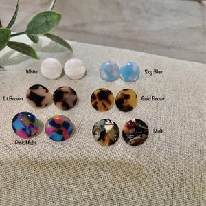May include: Assortment of 10 pairs of round resin earrings in various colors and patterns, including white, sky blue, light brown, gold brown, pink multi, and multi.