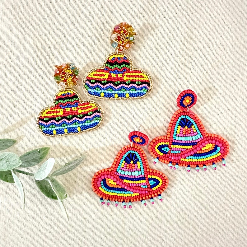 K&ouml;nnte beinhalten: Ein Paar bunte Perlenohrringe in Form von Sombreros. Die Ohrringe sind aus roten, orangefarbenen, gelben, gr&uuml;nen, blauen und violetten Perlen gefertigt. Die Ohrringe sind ein lustiges und festliches Accessoire f&uuml;r jeden Anlass.