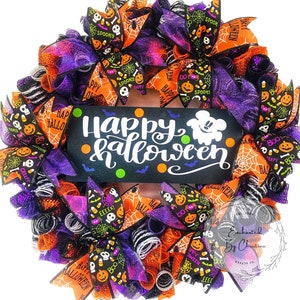 May include: A Halloween wreath with orange, purple, and black mesh and ribbons. The wreath features a sign that says "Happy Halloween" with a ghost and bats.