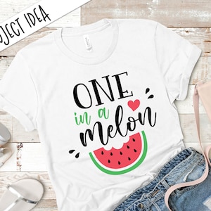 May include: White t-shirt with black text that reads "One in a melon" with a red heart and a green watermelon graphic.