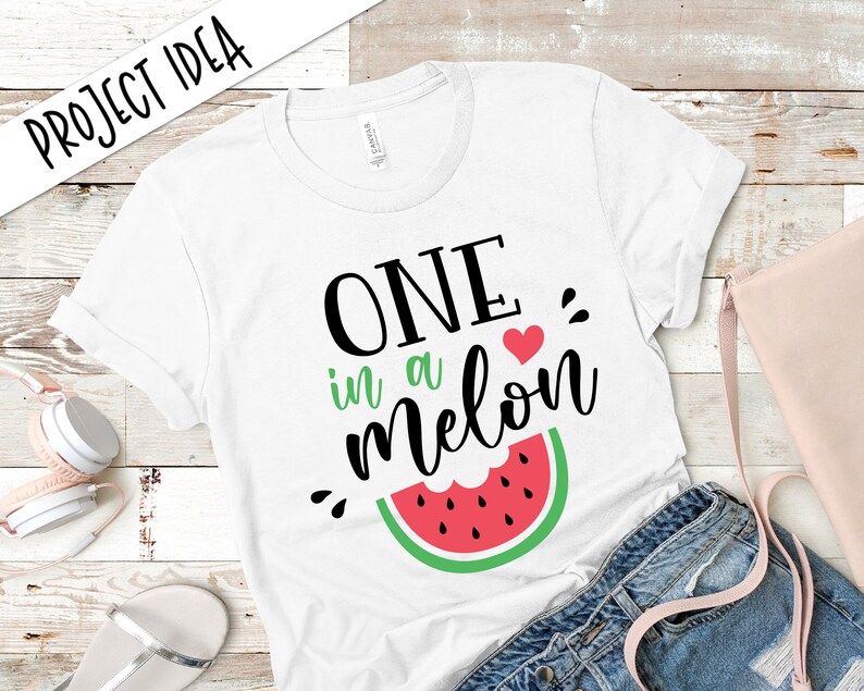 May include: White t-shirt with black text that reads "One in a melon" with a red heart and a green watermelon graphic.