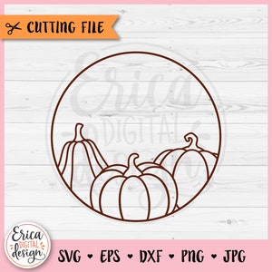 May include: A brown outline of three pumpkins inside a circle. The pumpkins are arranged in a row with the largest pumpkin in the center. The circle has a brown outline and is on a white wood background.