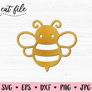 Könnte beinhalten: Eine goldene Bienensilhouette mit schwarzen Streifen und weißen Augen. Die Biene ist eine Schnittdatei für Bastelprojekte.
