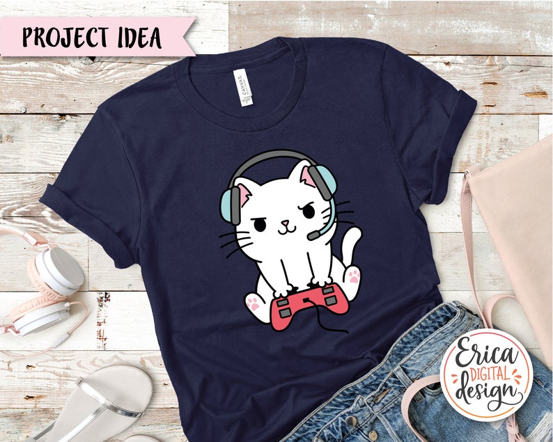 Op de afbeelding: Een marineblauw t-shirt met een witte kat die een koptelefoon draagt en een rode videogamecontroller vasthoudt. De tekst "Project Idea" staat bovenaan de afbeelding.