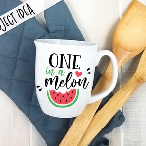 May include: White ceramic mug with a black and white graphic that says "One in a melon" with a red heart and a green watermelon graphic.