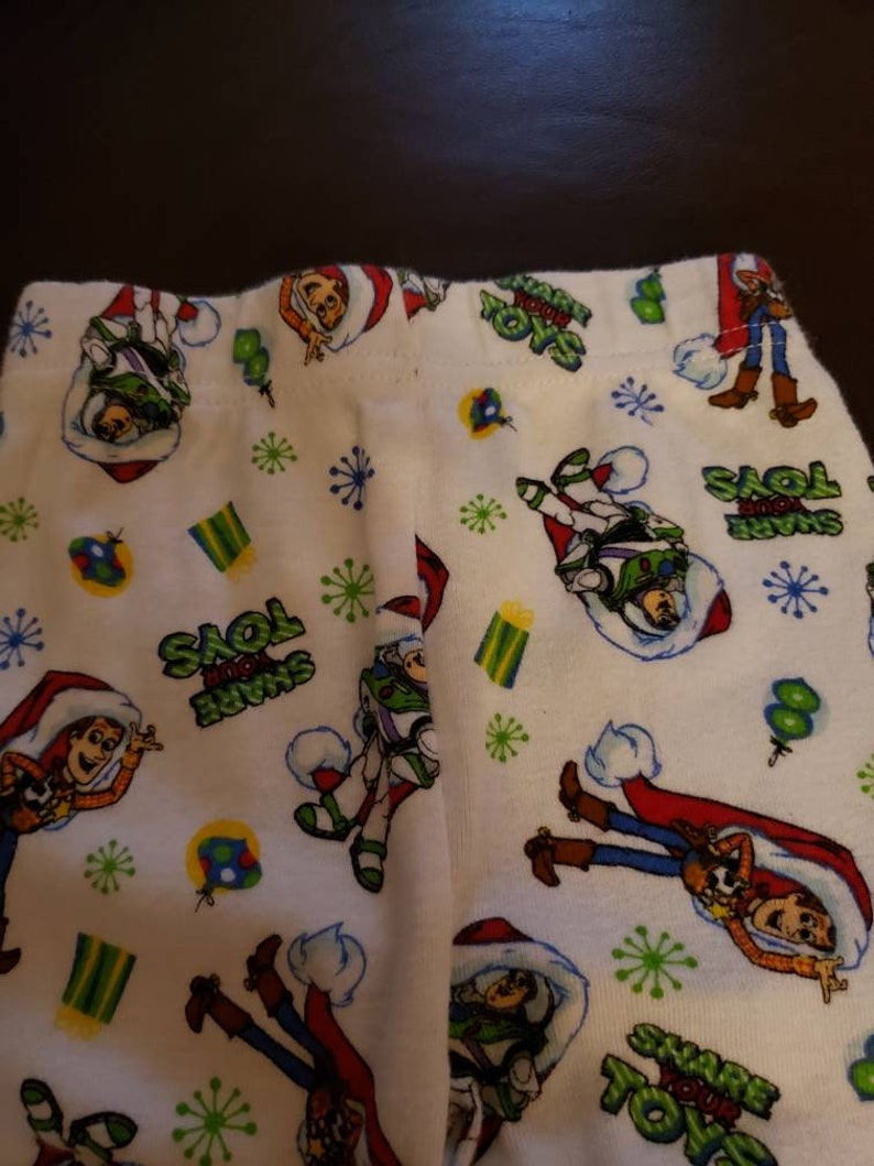 Share your Toys on it. Disney Pixar Toy Story Holiday pajamas Size 2T Long sleeve shirt and pants Woody and Buzz Lightyear have santa hats