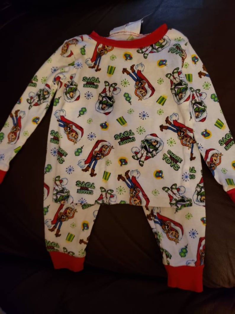 Share your Toys on it. Disney Pixar Toy Story Holiday pajamas Size 2T Long sleeve shirt and pants Woody and Buzz Lightyear have santa hats