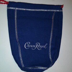 May include: A blue drawstring bag with white stitching and the words "Crown Royal" embroidered in white.