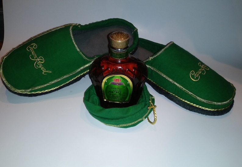 May include: Two green slippers with gold embroidery that reads "Crown Royal" and a small bottle of Crown Royal Canadian whisky in a green drawstring bag.