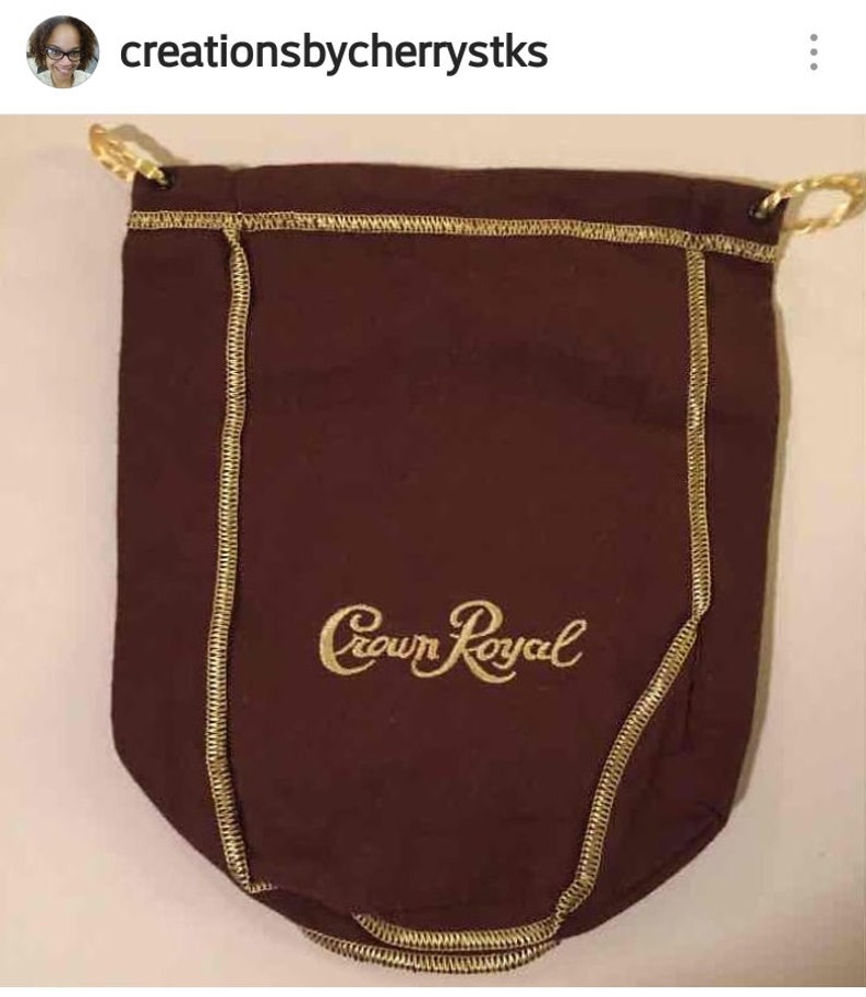 May include: A brown drawstring bag with gold stitching and the words "Crown Royal" embroidered in gold.