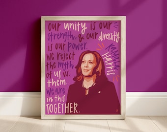 May include: A framed art print featuring a stylized portrait of Kamala Harris in shades of dark red and brown against a magenta background. The text reads: our unity is our strength, & our diversity is our power. we reject the myth of us vs. them. we are in this TOGETHER. Kamala Harris.