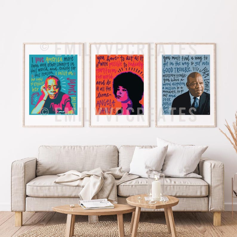 May include: Three framed art prints featuring portraits and quotes. The left print shows James Baldwin with blue text. The center print features Angela Davis in orange and pink. The right print displays John Lewis in a suit with blue text.