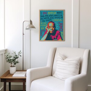 May include: A rectangular framed wall art print featuring a stylized portrait of James Baldwin in shades of pink, red, and dark blue. The background is teal with hand-lettered text in yellow and dark blue that reads, I love America more than any other country in this world, and, exactly for this reason, I insist on the right to criticize her perpetually.