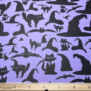 May include: A sheet of purple paper with black paper cutouts of witches' hats and cats. The cutouts are scattered across the paper in a random pattern.